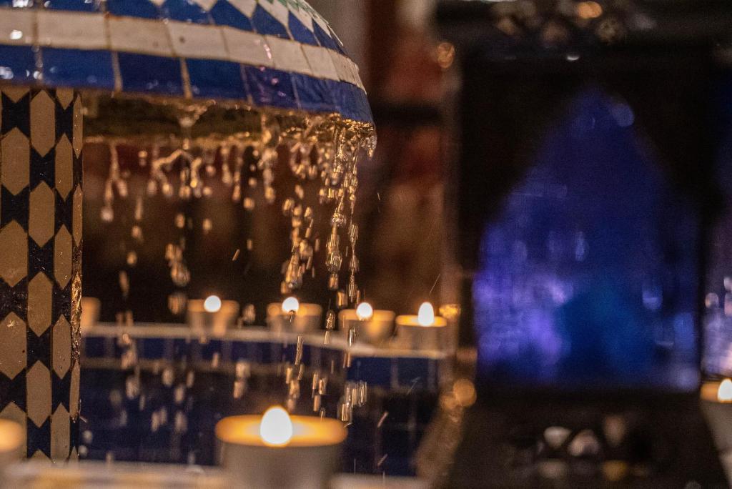 een groep kaarsen en een tafel met een kroonluchter bij Riad bel kayed in Fès