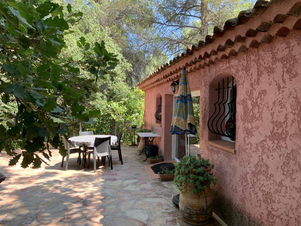 un patio de una casa con mesa y sillas en Bastidon CEZANNE en Aix-en-Provence