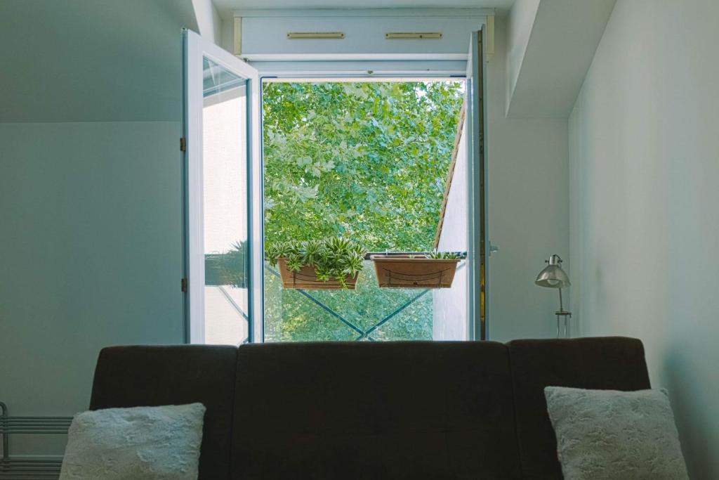 uma sala de estar com um sofá em frente a uma janela em Luka's charming apartment near Disneyland em Magny-le-Hongre