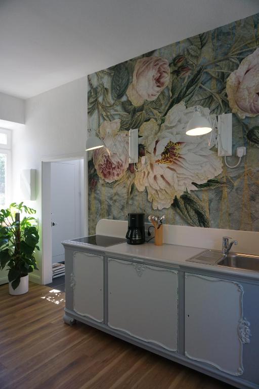 a kitchen with a flower mural on the wall at Rosalinde in Lüneburg