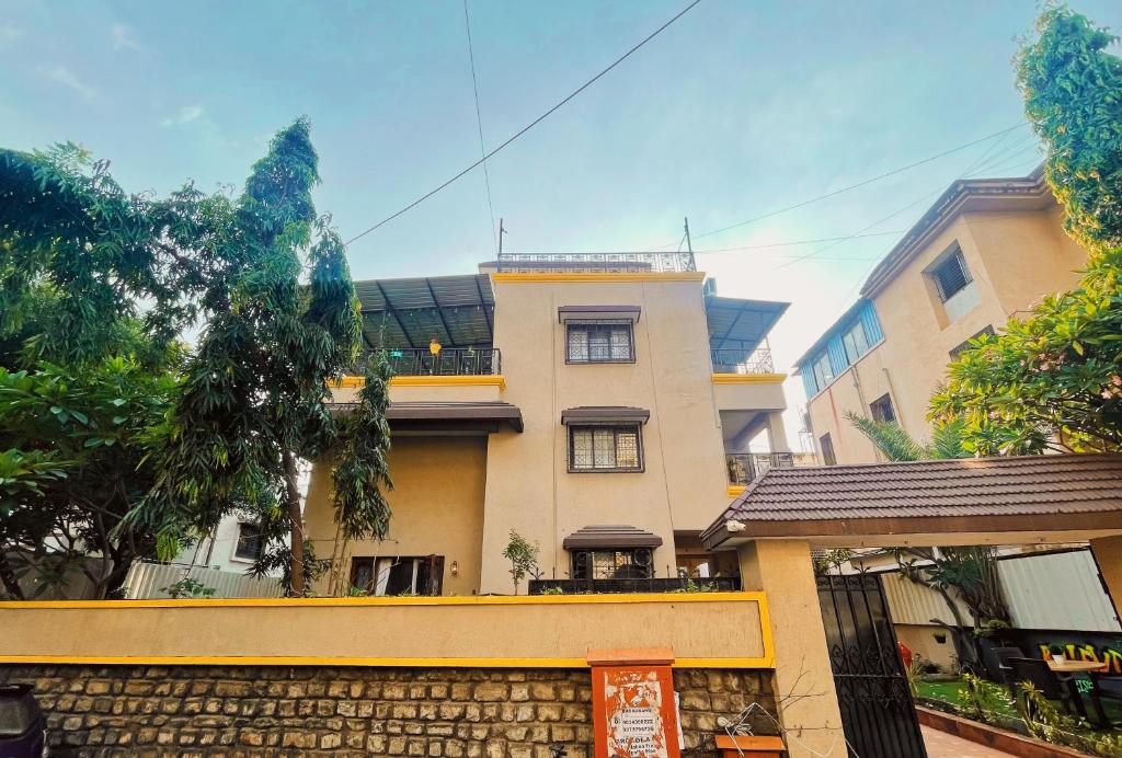 un edificio con una valla delante en Bern Hostel By Vibe Village, en Pune