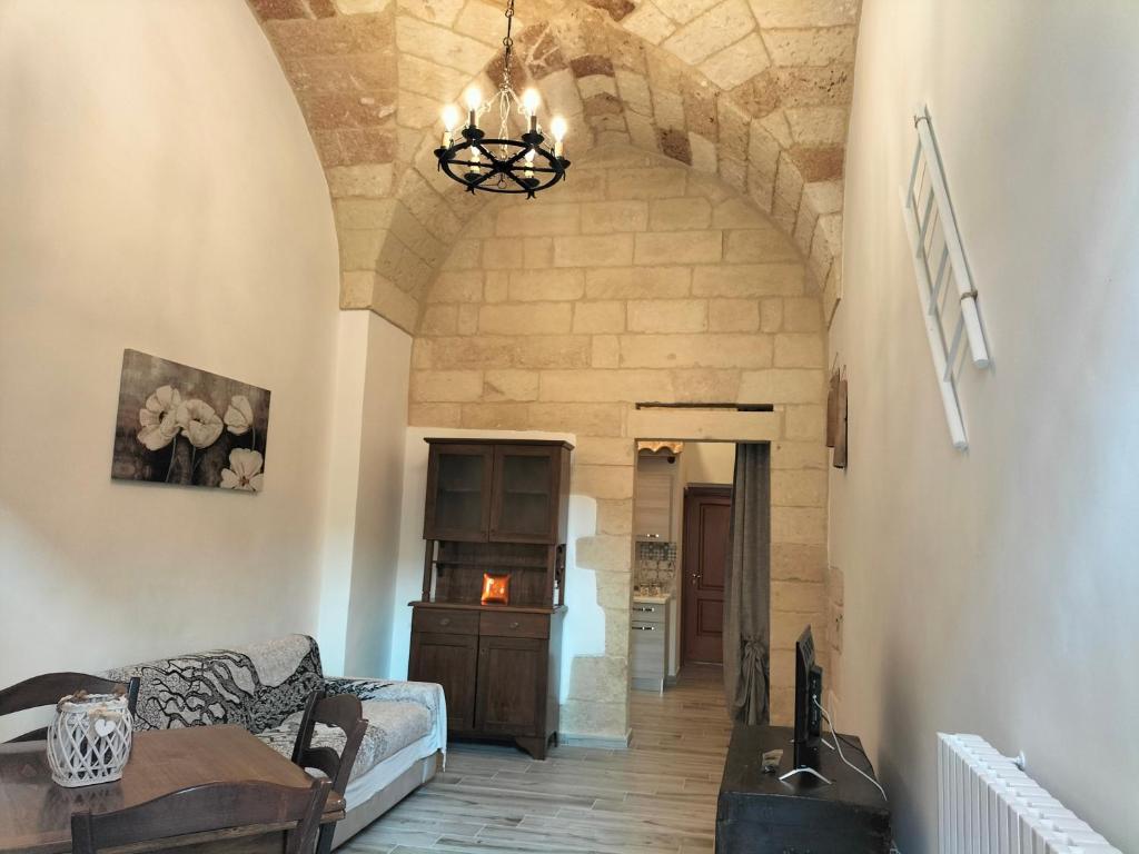 ein Wohnzimmer mit einem Sofa und einem Kronleuchter in der Unterkunft La tegola in Lecce
