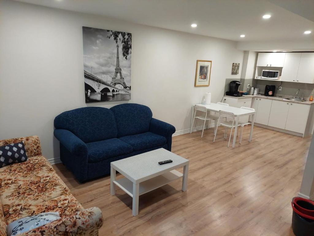a living room with a blue couch and a table at Spacious basement one bedroom apartment, WiFi. in Montreal