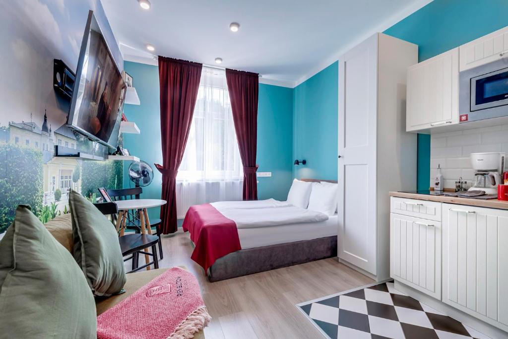 een kleine kamer met een bed en een keuken bij Revelton Studios Prague in Praag