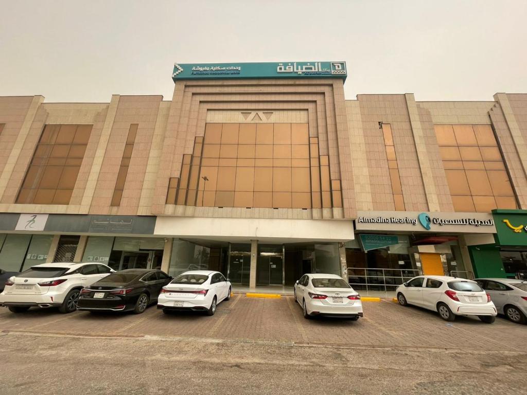 a building with cars parked in a parking lot at Al Diafah Housing Furnished Units in Riyadh