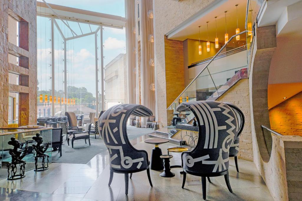 a lobby with two chairs and tables in a building at Tribe Hotel, Nairobi, a Member of Design Hotels in Nairobi