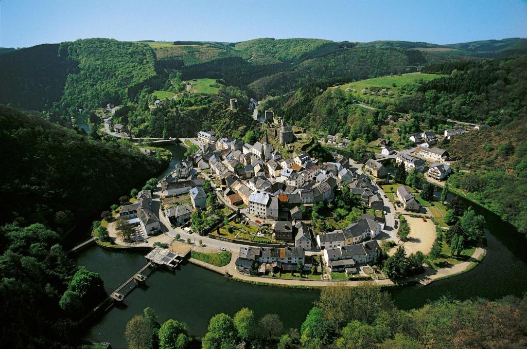 an aerial view of a village in the middle of a river at Logis Gourmet & Relax Hotel De La Sure in Esch-sur-Sûre