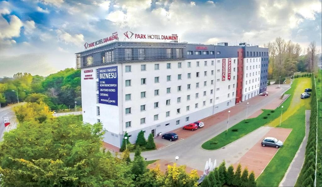ein weißes Gebäude mit einem Schild darauf in der Unterkunft Park Hotel Diament Katowice in Kattowitz