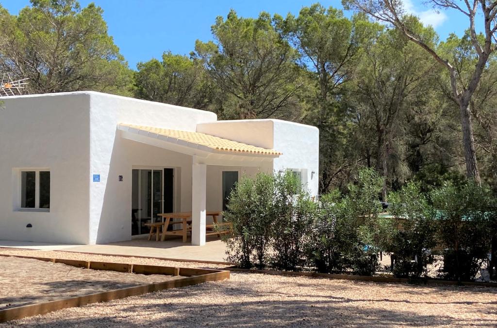 a white house with a table in front of it at Can Valonsadero, Villa con Piscina in Es Calo