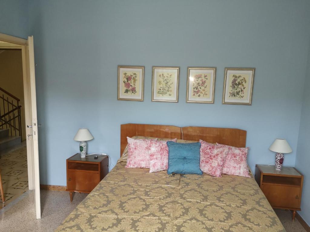 ein Schlafzimmer mit einem Bett mit drei Bildern an der Wand in der Unterkunft Villa Florida in Fiuggi