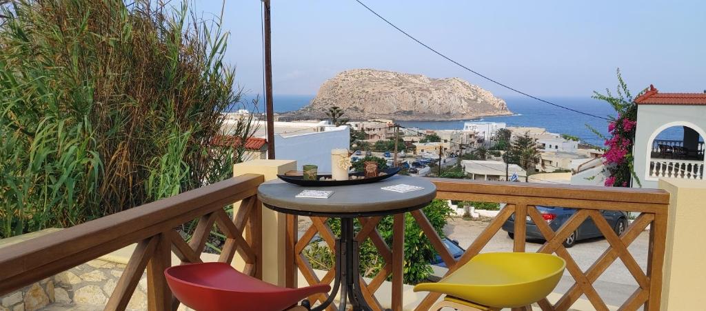 balkon ze stołem i krzesłami oraz oceanem w obiekcie Stavlos Country House w mieście Arkasa