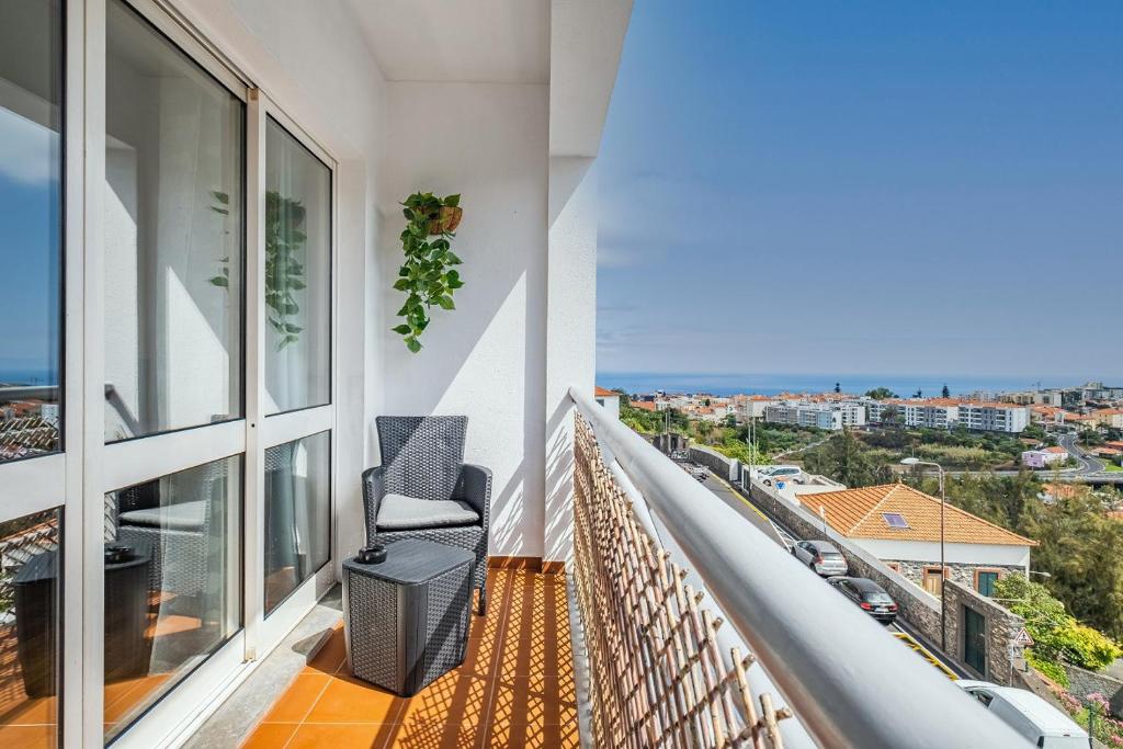 a balcony with a chair and a view of the city at My Place in Funchal by Madeira Sun Travel in Funchal