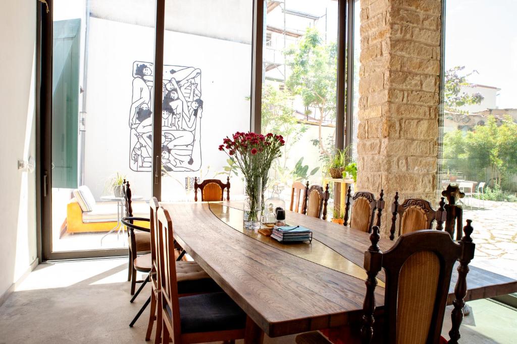 利馬索爾的住宿－MeMeraki Artist Residency，一间带木桌和椅子的用餐室