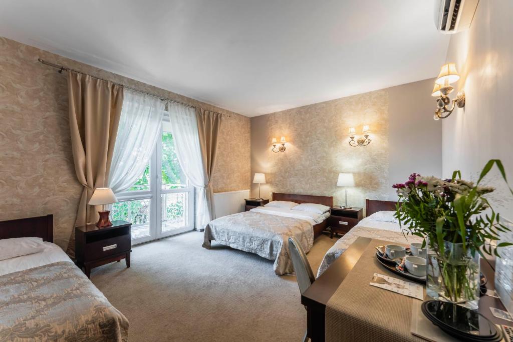 um quarto de hotel com duas camas e uma mesa em Pokoje w Portofino em Lublin