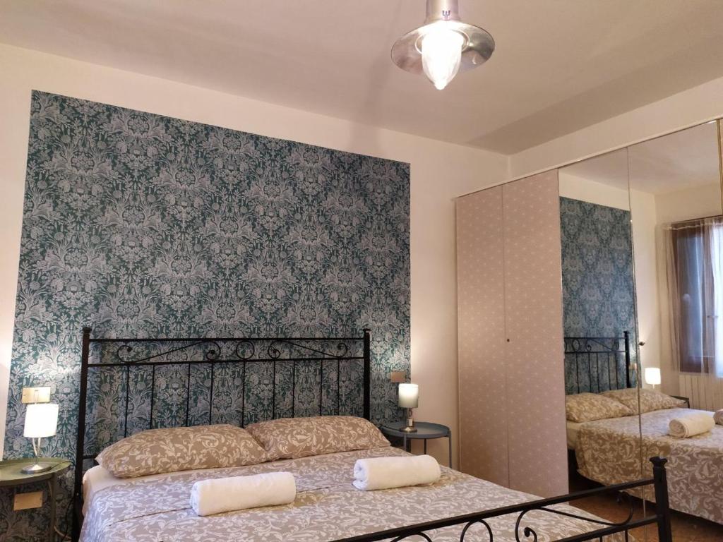 a bedroom with two beds and a mirror at Two Steps from Rialto in Venice