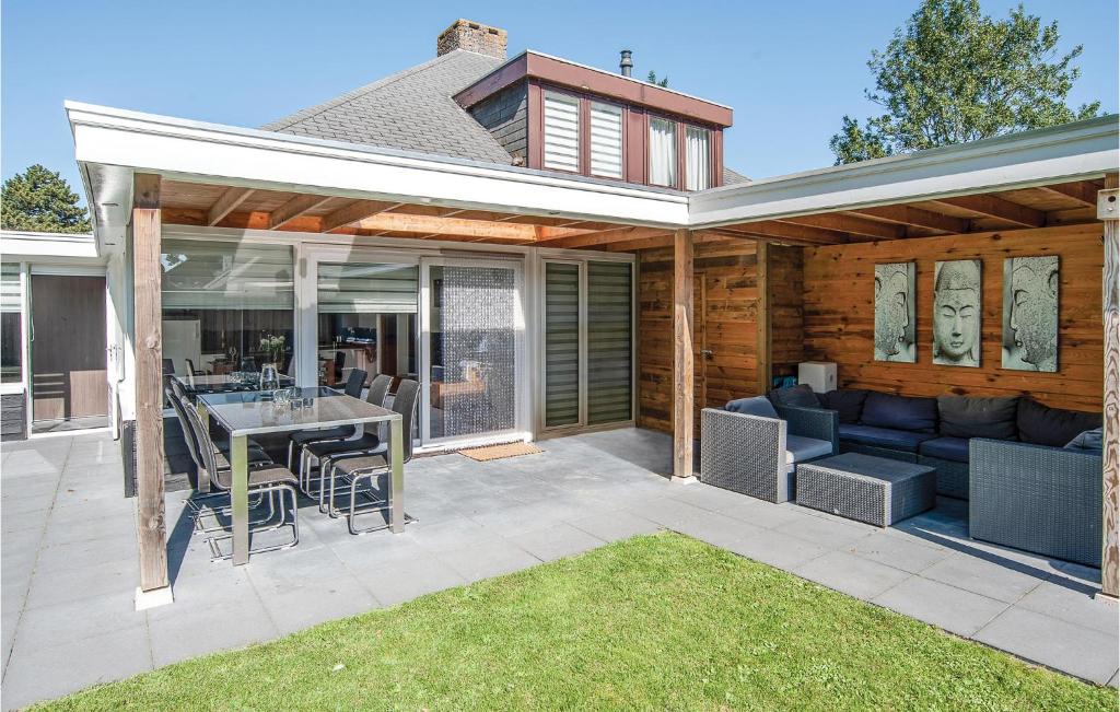 een patio met een bank en een tafel en stoelen bij Oud Kempen Bungalow 181 in Stavenisse