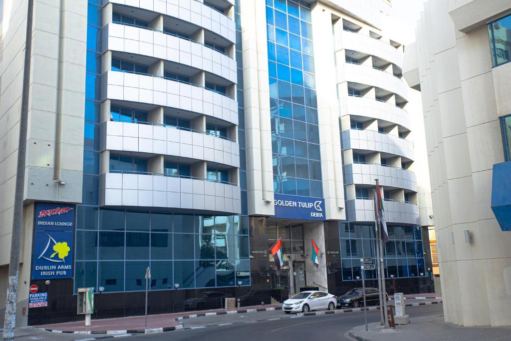 a building with a car parked in front of it at Golden Tulip Deira Hotel in Dubai