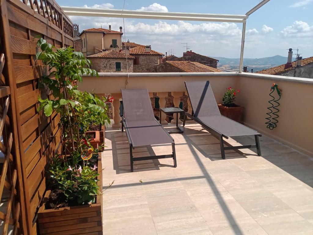 uma varanda com cadeiras e plantas num telhado em Locanda del Glicine em Campagnatico