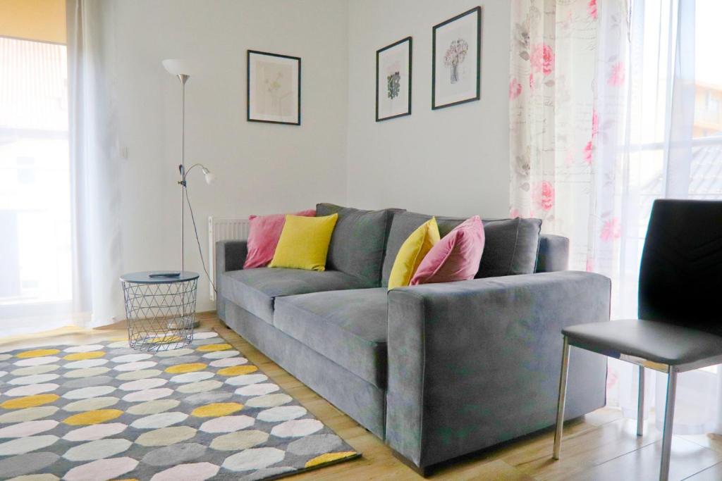 a living room with a gray couch with colorful pillows at visit baltic - Villa Julia Studio Mola in Świnoujście