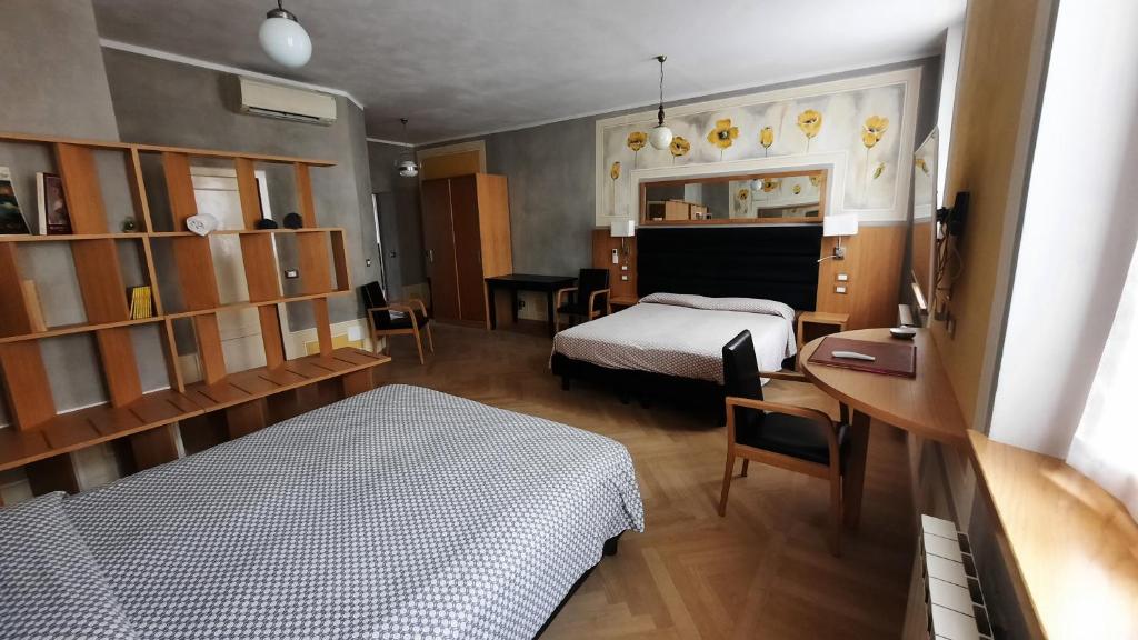1 dormitorio con cama, escritorio y cama sidx sidx sidx sidx en Albergo Giulia Gonzaga, en Sabbioneta