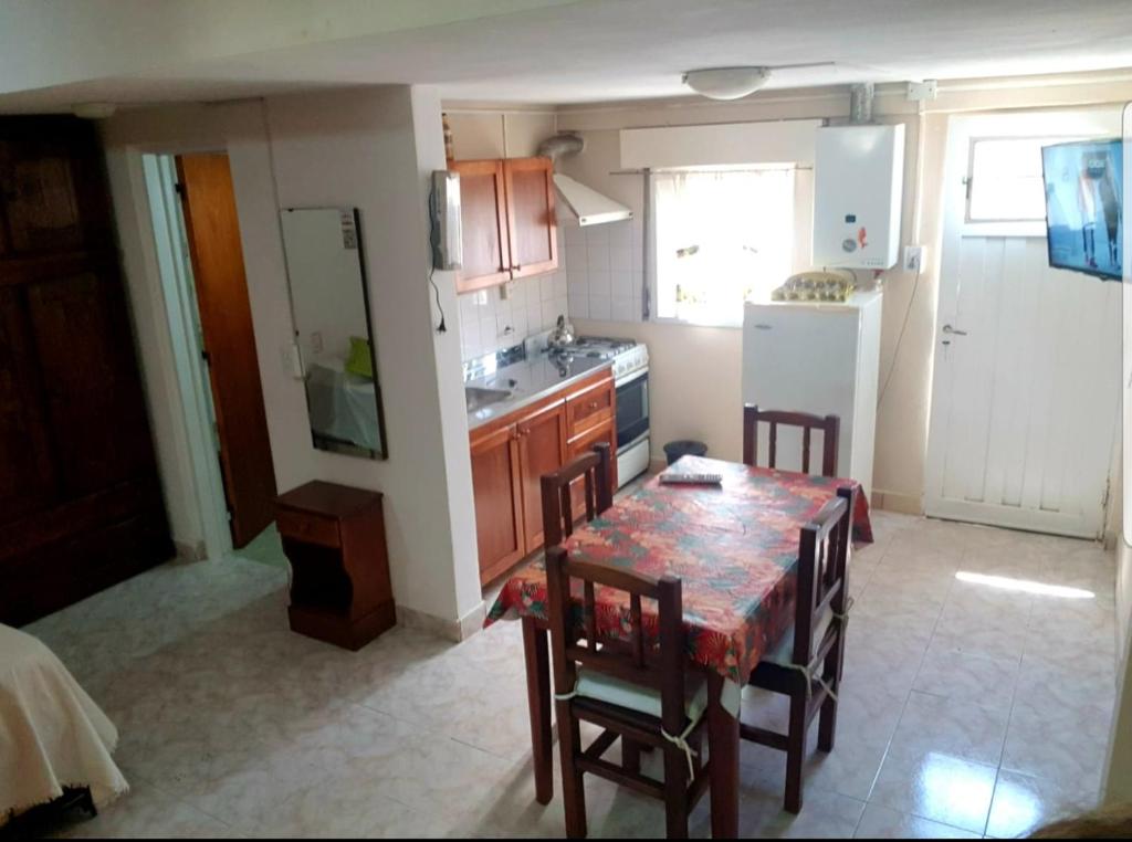 uma cozinha com uma mesa e cadeiras e um frigorífico em Lo de Liliana em Tanti