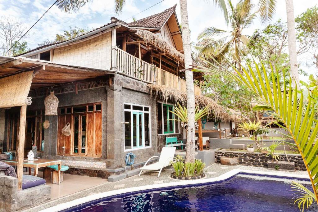 a house with a swimming pool in front of it at Unique Balian beach house in Antasari