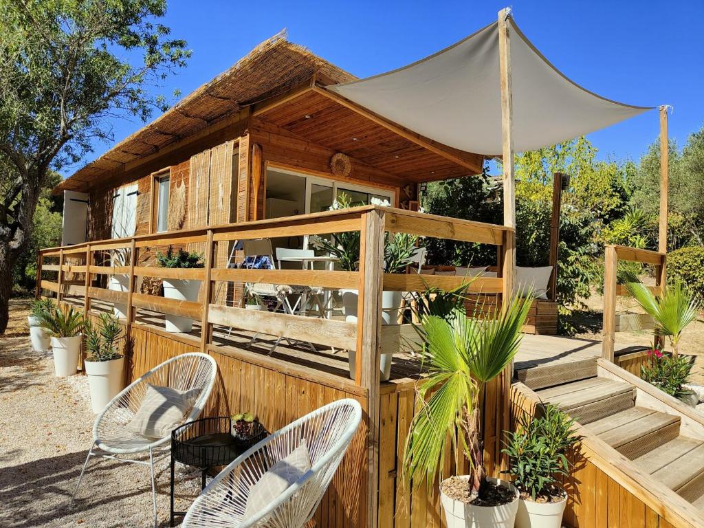 uma casa de madeira com duas cadeiras e uma tenda em Magnifique Cabanon face au Garlaban à Aubagne em Aubagne