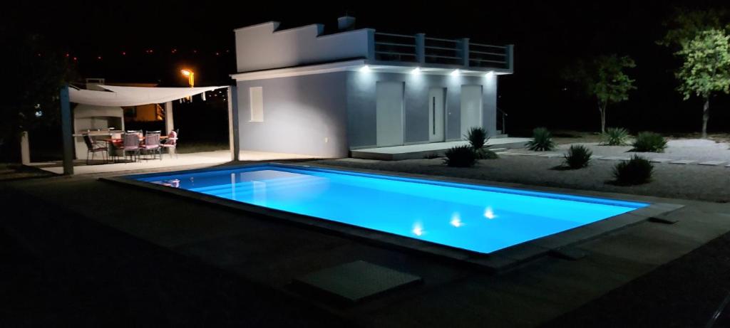a swimming pool in front of a house at night at Urban House M & M in Mostar