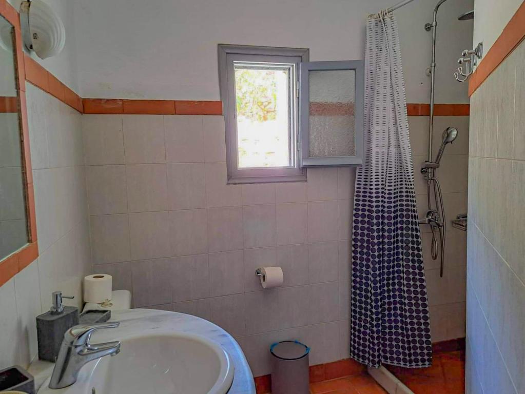 y baño con lavabo y ducha. en Sympopoula House en Sifnos