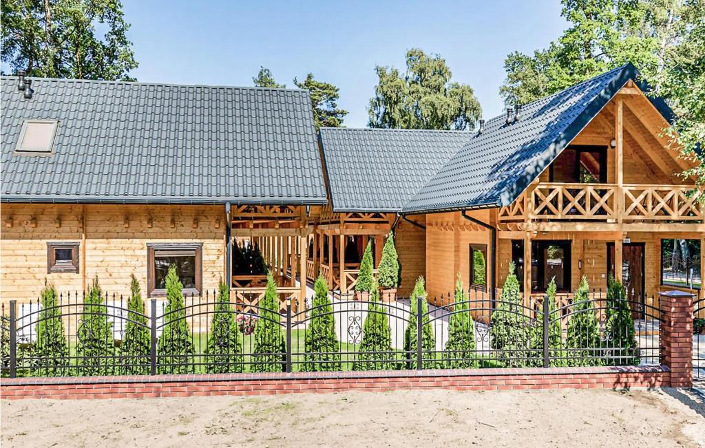 uma casa de madeira com uma cerca em frente em Stunning Home In Pobierowo With Kitchen em Pobierowo