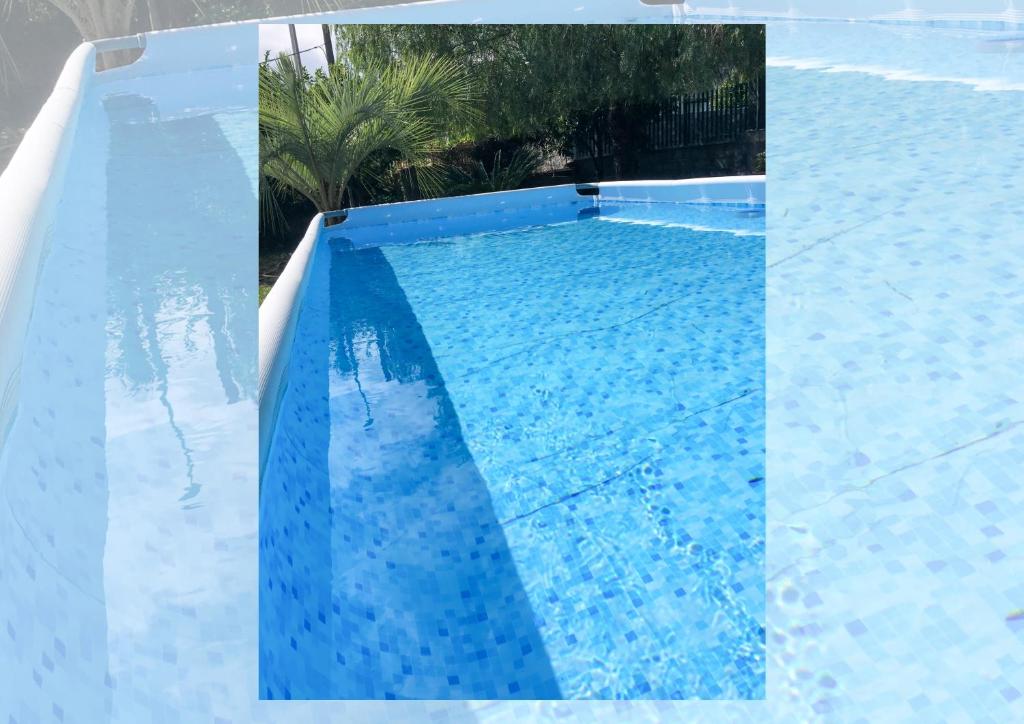 uma piscina com água azul numa casa em The King Ross em Santa Venerina
