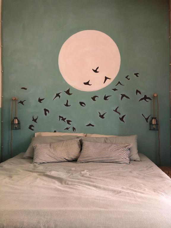 una camera da letto con un letto con uccelli sul muro di Corte Bargagli, dolce casa in palazzo toscano a Sarteano