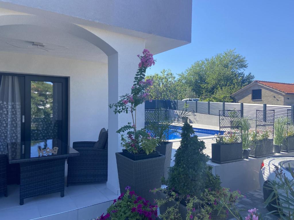 balcone con piante in vaso e piscina di HelaMoni, New 5 Star 2 Person apartment with private exclusive pool a Malinska