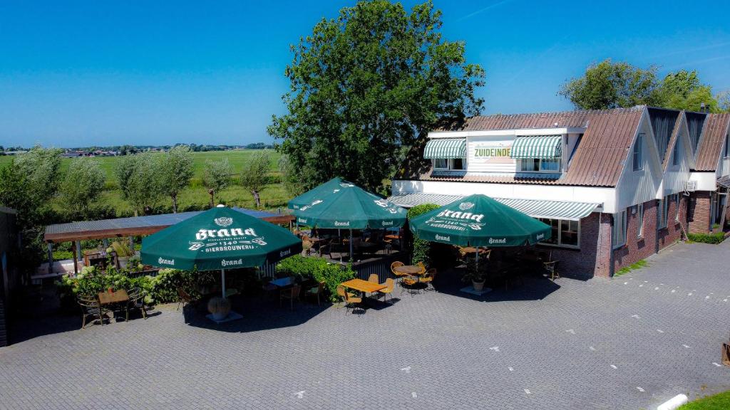 una vista aérea de un restaurante con mesas y sombrillas en Hotel Zuideinde en Nieuwkoop