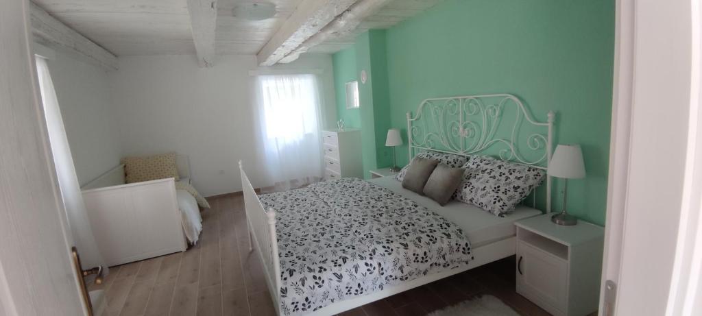 a bedroom with a bed with a green wall at Villa Nikšić in Otočac