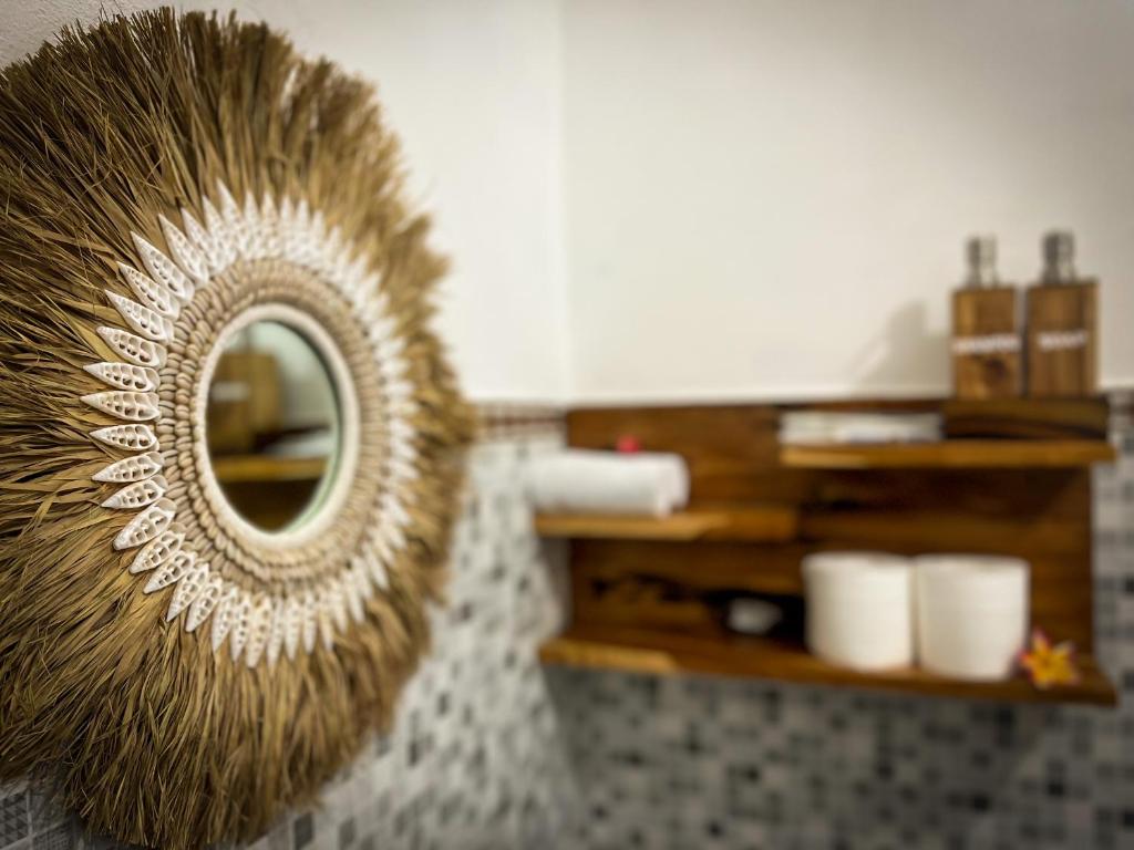 a mirror in a room with a shelf with toiletries at Griyatama Bungalow in Nusa Penida