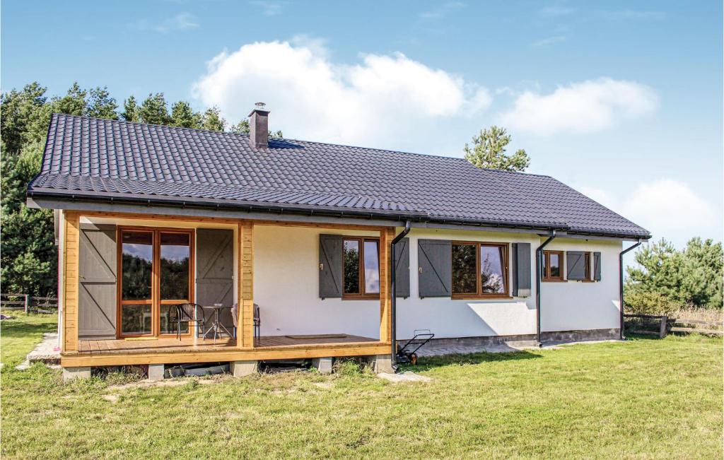 a small white house with a roof at Cozy Home In Kolczewo With Kitchen in Kołczewo