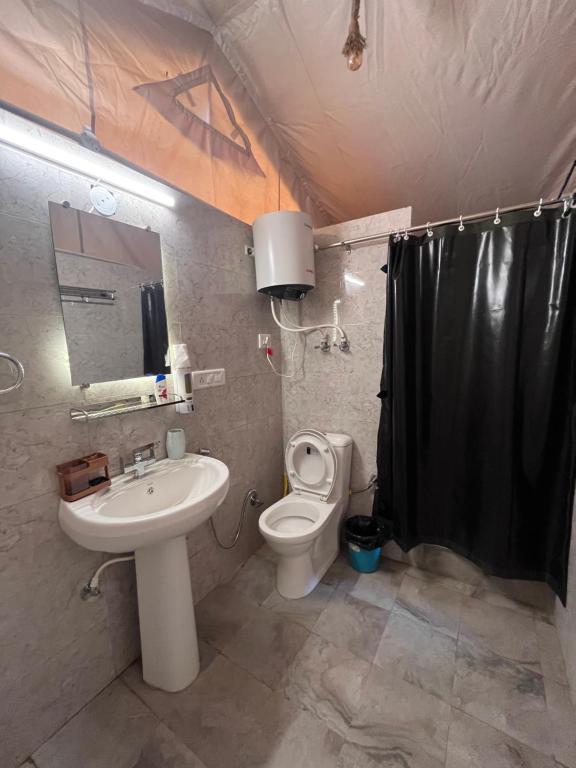 a bathroom with a sink and a toilet and a shower at H2H Bir l Nature Camps in Bīr