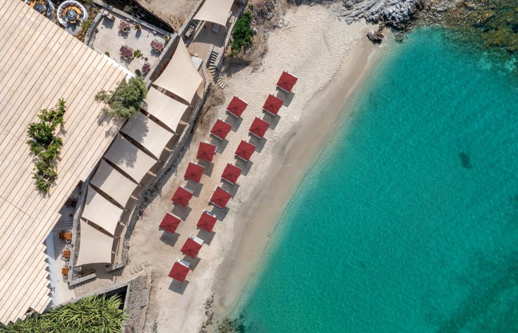 una vista sul tetto di una spiaggia con sedie e acqua di The Coast Bill & Coo -The Leading Hotels of the World ad Agios Ioannis