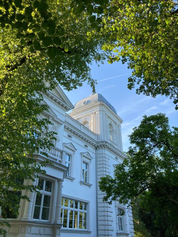 Biały budynek z wieżą zegarową na górze w obiekcie Stara Biblioteka we Wrocławiu