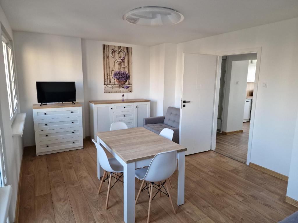 a dining room with a table and chairs in a room at Apartament Lawendowy Gdańsk in Gdańsk