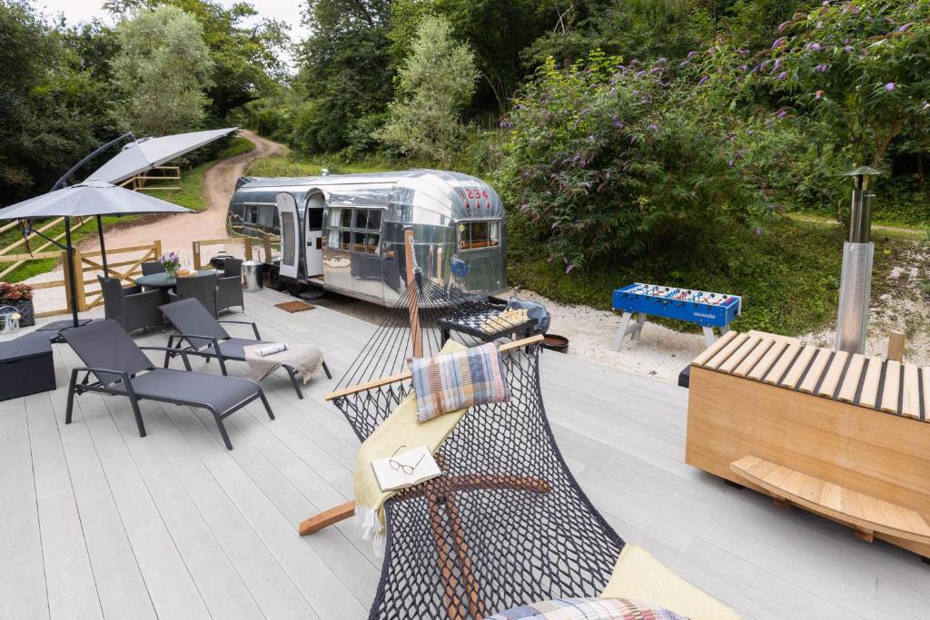 an outdoor deck with a guitar and a table and chairs at The 1956 Vintage American Airstream in Dittisham
