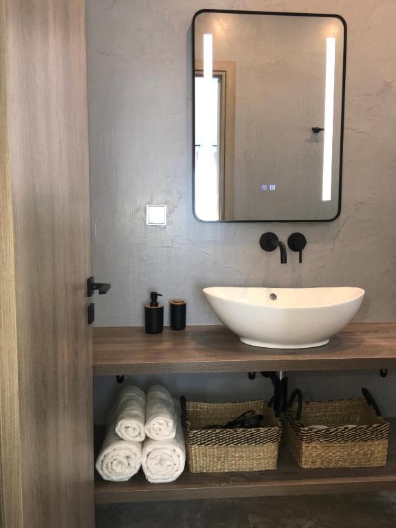 W łazience znajduje się umywalka, lustro i ręczniki. w obiekcie ANASTASIA LUXURY SUITES 2 w mieście Tolo