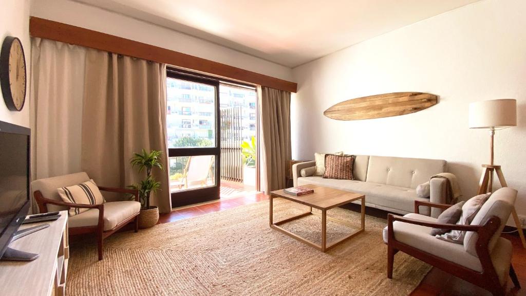 un soggiorno con divano e tavolo di Estoril Sunny Apartment a Estoril