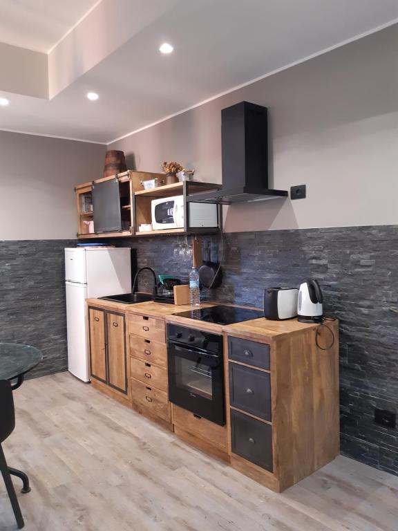 uma cozinha com armários de madeira e um forno com placa de fogão em Casa Pepito em Bogliasco