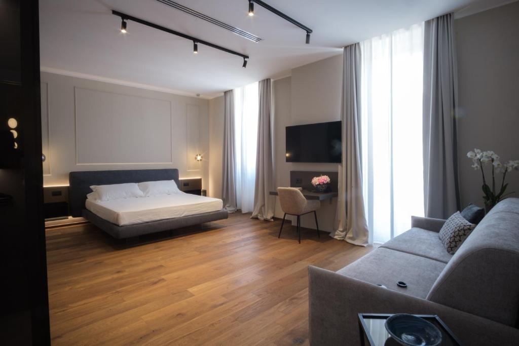 a bedroom with a bed and a living room with a couch at PALAZZO DANISI ROOMS&SUITES in Bari