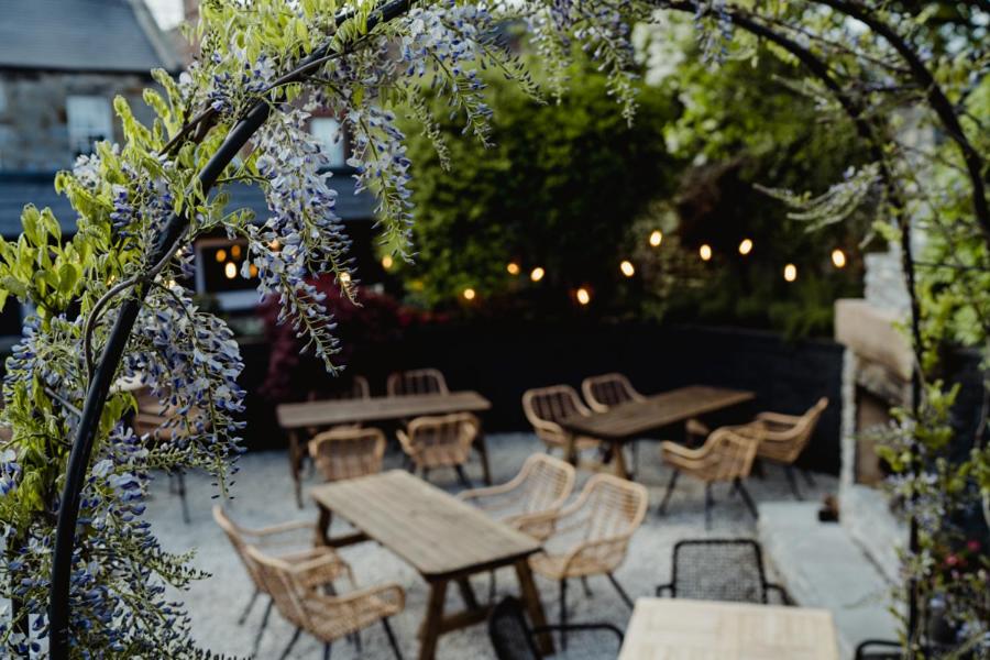a group of tables and chairs in a garden at The Bonnie Badger in Gullane