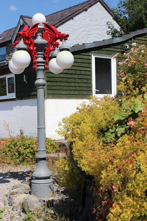 a street light with a red ribbon on top of it at Poplar Lodge, Dee Valley Stays - cosy microlodge with detached private shower & WC in Corwen