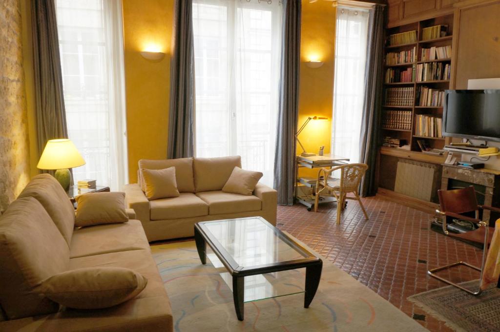 uma sala de estar com um sofá e uma mesa de centro em Le 38, rue Saint-Louis en l'île em Paris