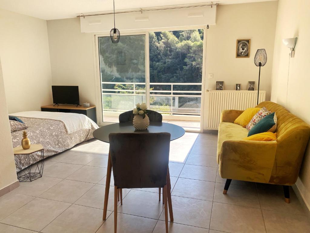 uma sala de estar com um sofá e uma mesa em Villa Madeleine - Résidence Services Seniors em Nice